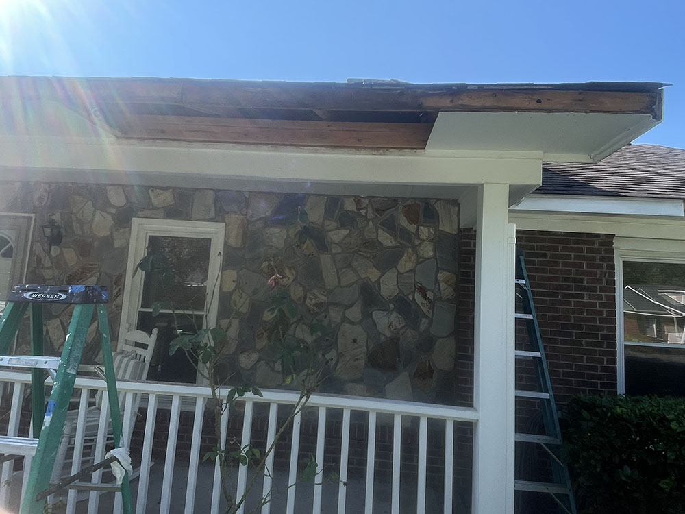 Rotted soffit and fascia torn out exposing roof rafters